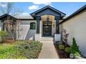 Stately front entrance featuring painted brick, updated trim, and mature landscaping at 5302 Pinehurst Dr, Boulder, CO 80301