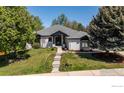 Charming single-story home featuring lush landscaping, a gray roof, and a welcoming front entrance at 5302 Pinehurst Dr, Boulder, CO 80301