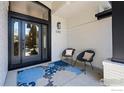 Charming front porch with modern decor, including chairs, pillows, and a stylish outdoor rug at 5302 Pinehurst Dr, Boulder, CO 80301