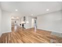 Spacious, open-concept living room with hardwood floors and recessed lighting at 5383 Meade St, Denver, CO 80221