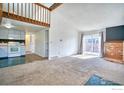 Bright living room featuring neutral carpet, exposed wood beams, fireplace, and sliding glass doors to patio at 607 5Th St, Frederick, CO 80530