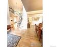 Bright and inviting foyer showcasing hardwood floors, elegant lighting and a grand staircase at 7281 Arco Iris Ln, Castle Pines, CO 80108