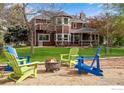 Inviting backyard area with colorful Adirondack chairs around a fire pit, perfect for outdoor gatherings at 7628 Estate Cir, Niwot, CO 80503