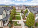 Aerial view of a well-maintained community with green spaces, mature trees, and mountain views at 8919 Yates Dr, Westminster, CO 80031