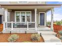 Charming front porch with seating area, brick accents, and manicured landscaping creates an inviting entrance at 8919 Yates Dr, Westminster, CO 80031