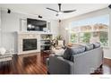 Comfortable living room with fireplace, hardwood floors, and large windows offering natural light at 119 Ortega Ct, Erie, CO 80516