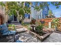 Beautiful backyard featuring a well-maintained lawn, stone patio, garden bed, and comfortable seating at 1278 Hummingbird Cir # D, Longmont, CO 80501