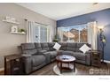Cozy living room with plush gray sectional sofa, hardwood floors, and plenty of natural light at 1278 Hummingbird Cir # D, Longmont, CO 80501