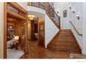 Elegant foyer with hardwood floors, wainscoting, and a staircase leading to the upper level at 13042 Logan St, Thornton, CO 80241