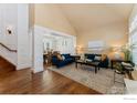 Bright living room featuring hardwood floors, large windows, and stylish furniture, offering a comfortable space at 13042 Logan St, Thornton, CO 80241