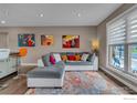 Bright living room featuring hardwood floors, a large window, and a cozy seating area with stylish decor at 1419 Fillmore Pl, Louisville, CO 80027
