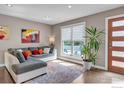 Bright living room featuring hardwood floors, a large window, and a cozy seating area with stylish decor at 1419 Fillmore Pl, Louisville, CO 80027
