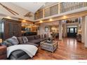 Open-concept living room showcasing hardwood floors, lofted ceilings and an adjacent dining area at 14582 Homestead Pl, Broomfield, CO 80023