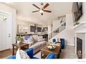 Open-concept living space with stylish furnishings, fireplace, and seamless flow to the dining and kitchen areas at 1481 Harebell St, Berthoud, CO 80513