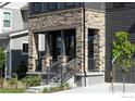 Close-up of the front porch featuring stone pillars, a wooden beam, and gray wooden siding at 1592 Ash Dr, Erie, CO 80516