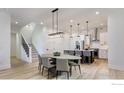 Open-concept kitchen and dining area with a large island, modern lighting, and stainless steel appliances at 1592 Ash Dr, Erie, CO 80516