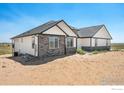 The rear of the house featuring white siding, a stone foundation, and a covered back patio at 16474 Essex S Rd, Platteville, CO 80651