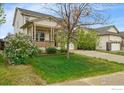 Suburban home featuring a covered porch, well-kept lawn and a long driveway leading to a two-car garage at 1736 Trevor Ct, Longmont, CO 80501