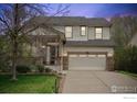 Traditional home with a welcoming front porch, two car garage, and lush green lawn at 1736 Trevor Ct, Longmont, CO 80501