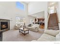 Spacious living room with fireplace, adjacent to the kitchen and staircase at 1736 Trevor Ct, Longmont, CO 80501