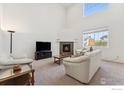 Bright living room featuring a fireplace, plush seating, and tall ceilings at 1736 Trevor Ct, Longmont, CO 80501