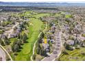 Stunning aerial view showcasing the home's location adjacent to a lush golf course with mountain views in the distance at 2206 Eagles Nest Dr, Lafayette, CO 80026