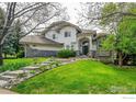 Beautiful home featuring a well-maintained lawn, stone accents, and a welcoming entrance framed by mature trees and landscaping at 2206 Eagles Nest Dr, Lafayette, CO 80026