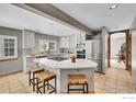 Stylish kitchen featuring an island with seating, modern appliances, white cabinets, and a view into the adjacent dining area at 2206 Eagles Nest Dr, Lafayette, CO 80026