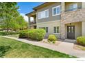 Charming condo facade featuring stone accents, a private entrance, and well-maintained greenery at 2239 Calais Dr # F, Longmont, CO 80504