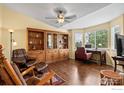 Cozy living room featuring a built-in bookcase, comfortable seating, and ample natural light at 2304 Dogwood Dr, Erie, CO 80516