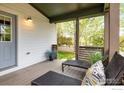This home features a cozy, covered porch with stylish seating and views of the landscaped yard at 2552 Stonewall Ln, Lafayette, CO 80026