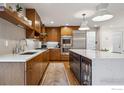 This kitchen boasts a large island, a wine fridge, stainless steel appliances, and sleek cabinetry at 2575 Cragmoor Rd, Boulder, CO 80305