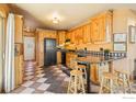 Functional kitchen with knotty wood cabinets, black appliances, and tiled flooring at 265 31St St, Boulder, CO 80305