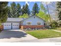 Charming single-story home with a well-manicured lawn, brick accents, and a two-car garage at 27 Cornell Dr, Longmont, CO 80503