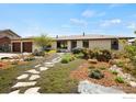 Inviting home with stone walkway, mature landscaping, and a two-car garage at 2721 Villanova Ct, Longmont, CO 80503