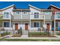 Charming townhome exterior featuring a fenced front yard, multiple stories, and private balconies at 2732 Bear Springs Cir, Longmont, CO 80503