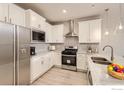 Modern kitchen featuring white cabinetry, stainless steel appliances, and granite countertops at 2732 Bear Springs Cir, Longmont, CO 80503