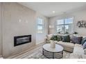 Bright living room with a modern fireplace, white sofa, and decorative accents at 2732 Bear Springs Cir, Longmont, CO 80503