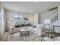 Cozy living room featuring a large white sectional sofa, stylish decor, and natural light at 2732 Bear Springs Cir, Longmont, CO 80503