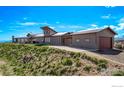 Modern home exterior on a hillside features a garage and a concrete driveway at 399 Northview Rd, Berthoud, CO 80513