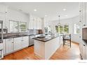 Spacious kitchen with white cabinetry, stainless steel appliances, and a large island at 4212 E Orchard Pl, Centennial, CO 80121