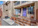 Cozy front porch with seating, plants, and a vibrant purple door adding character to the home at 5086 Buckingham Rd, Boulder, CO 80301