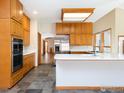 Well-lit kitchen with stainless steel appliances, a central island, and light countertops with wood cabinets at 6668 Fairways Dr, Longmont, CO 80503