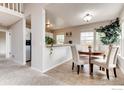 Cozy dining area adjacent to the kitchen, featuring a round table and ample natural light at 87 Macon Ct, Aurora, CO 80010