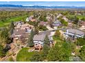 Overhead view of a neighborhood with lush trees, green lawns, and a golf course in the distance at 9980 Newton Ct, Westminster, CO 80031