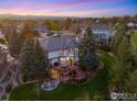 Expansive backyard featuring a large deck, stone patio with fire pit, and lush landscaping at 9980 Newton Ct, Westminster, CO 80031