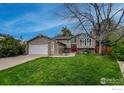 Charming home featuring a well-manicured lawn, brick accents, and a vibrant red front door at 1561 Belmont Dr, Longmont, CO 80503