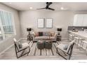 Bright living room featuring modern decor, a ceiling fan, and plank floors at 157 Ambrose St, Erie, CO 80516