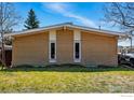 Charming brick home with well-maintained lawn and mature trees under a blue sky at 1573 S Dexter Way, Denver, CO 80222