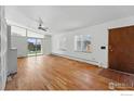 Spacious living room with hardwood floors, abundant natural light, and modern ceiling fan at 1573 S Dexter Way, Denver, CO 80222